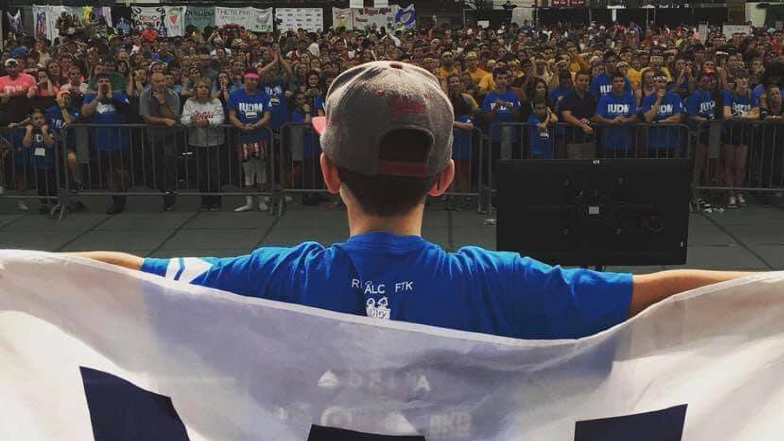 Dane Farlee in front of a crowd with a W flag