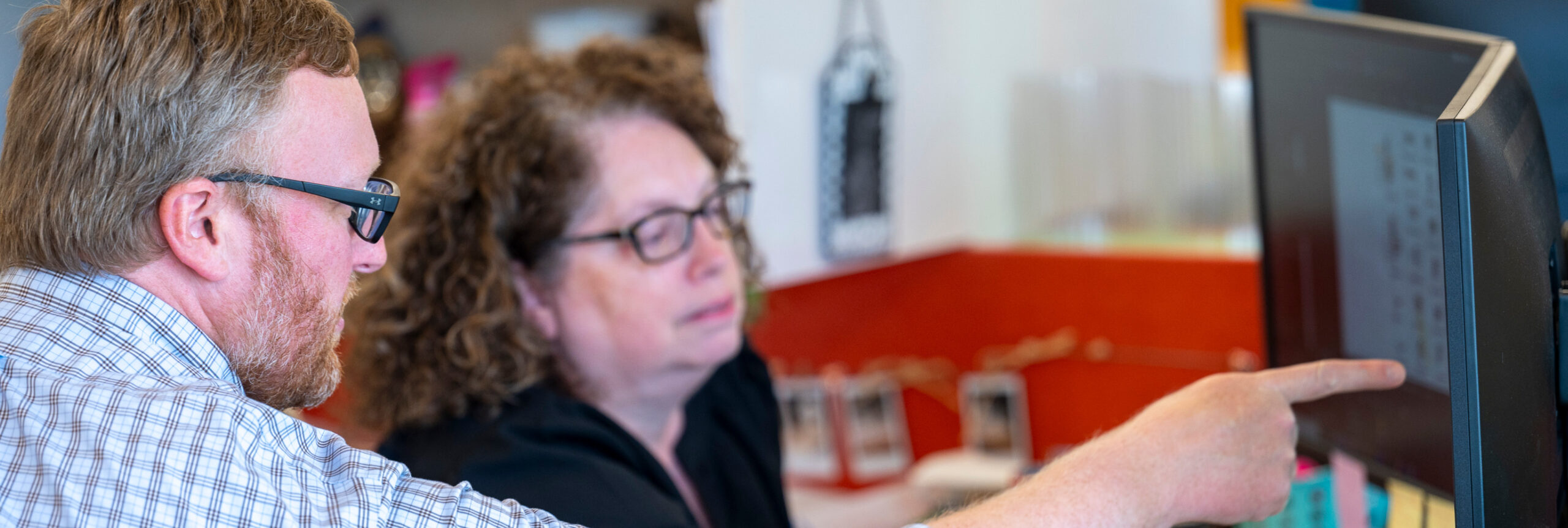 An architect and Senior Architectural Design Technician collaborating at a computer collaborating